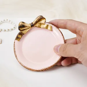 Primer plano de una bandeja de joyería rosa de lujo francés con un elegante lazo dorado