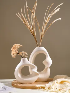 Macro view of Nordic spiral resin vases featuring an abstract hollowed design and matte texture