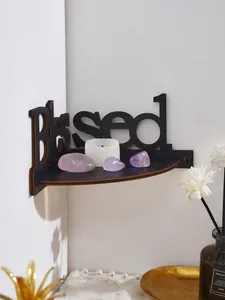 Detalle de la estantería de esquina de madera negra con diseño Blessed tallado a mano.