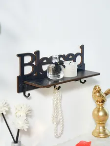 Dettaglio mensola in legno nero 'Blessed' con ganci e decorazioni per la casa