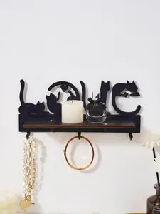 Close-up of black cat silhouette LOVE wall shelf with jewelry and decorative candle