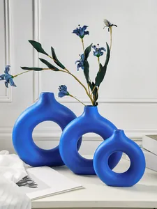 Moderne mat Klein blauwe keramische donutvazen in drie maten voor minimalistische deco.