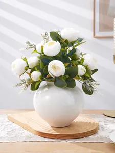 Detalle de elegante ramo de peonías artificiales blancas en jarrón cerámico decorativo