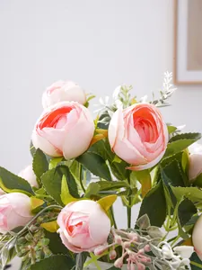 Detalle de cerca de pétalos de peonía artificial rosa y hojas de seda verde exuberantes