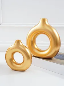 Close-up detail van elegante matgouden ringvormige vazen voor minimalistische decoratie