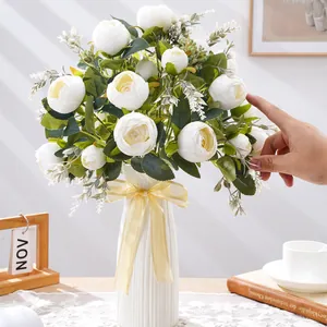 Elegante ramo de peonías artificiales blancas en un jarrón blanco para decoración.