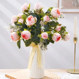 Elegante arreglo de peonías artificiales rosas en un jarrón blanco acanalado moderno