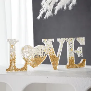 Gedetailleerd beeld van de LOVE hars letterdecoratie met bladgoud en witte steentjes