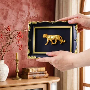 Detailed view of vintage black and gold DIY photo frame with gold leopard sculpture