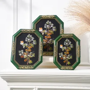 Detailed view of three vintage green octagonal frames with gold floral resin accents.
