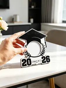 Dettaglio di una cornice per foto a forma di tocco da laureato in bianco e nero 2026