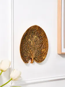 Vue détaillée de la décoration murale artistique en résine feuille tropicale dorée