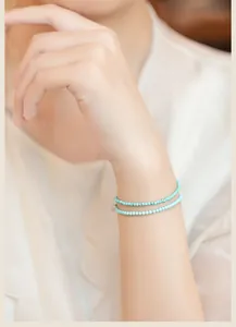 Close-up of a minimalist 2mm natural turquoise bead bracelet worn on a female wrist.
