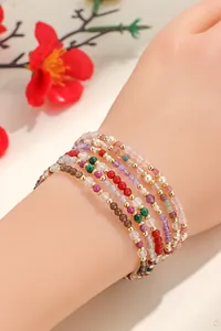 Primer plano de pulseras de cuentas de colores con piedra lunar y malaquita en la muñeca