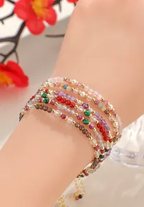 Detalle de pulseras de cuentas de cristal de colores con malaquita y luna.