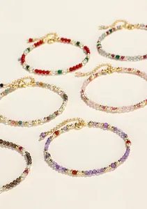 Vista macro de pulseras de cuentas de cristal coloridas con detalles dorados y cadenas