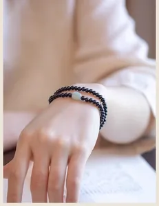 Primer plano de pulsera minimalista de cuentas de ébano de 4mm con detalle de jade