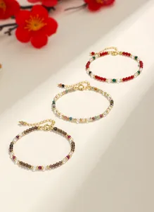 Vista detallada de tres delicadas pulseras de cuentas de piedras preciosas con cierres dorados.