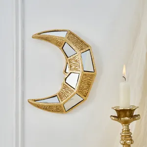 Détail d'une décoration murale en croissant de lune doré avec miroirs et texture vintage