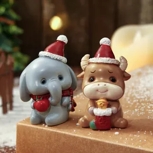 Makroansicht von niedlichen Harzfiguren von Elefant und Stier mit Weihnachtsmützen.