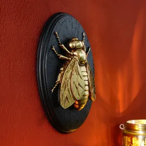 Detailed macro side view of a vintage gold insect resin relief wall hanging decor