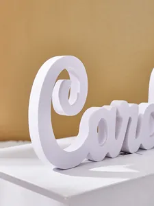 Macro view of white PVC foam board letter decoration showing smooth texture and finish.