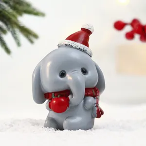 Nahaufnahme einer süßen Elefantenfigur aus Harz mit roter Weihnachtsmütze und Schal