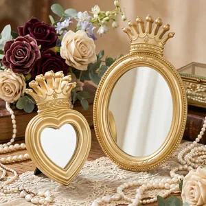 Detail view of gold crown mirrors in oval and heart shapes with vintage rose decor