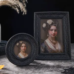 Nahaufnahme von schwarzen Vintage-Bilderrahmen mit Blumenrelief und klassischem Porträt
