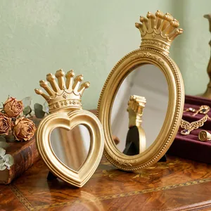 Detail of vintage gold crown-topped tabletop mirrors in heart and oval shapes for vanity