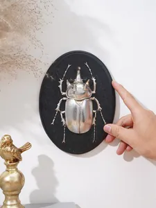 Decorazione murale a rilievo con scarabeo d'argento su base ovale in resina nera