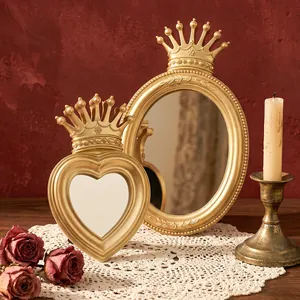 Detailed close-up of vintage gold crown heart and oval vanity mirrors in romantic setting