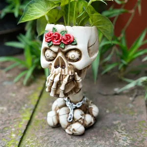 Detailed close-up of a vintage skull planter with red roses and silver chain decoration