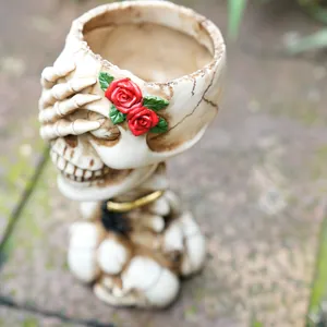 Detailed view of a vintage skull-shaped makeup brush holder with elegant red roses