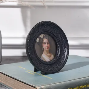 Detailansicht eines schwarzen ovalen Fotorahmens im Retro-Stil mit Blumenrelief