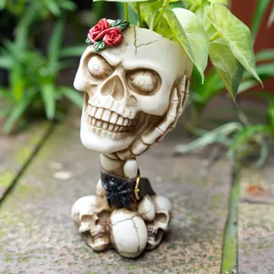 Detailed close-up of a gothic skull planter featuring a red rose and spider accents
