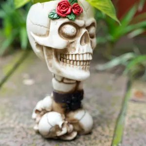 Detailed close-up of a vintage skull planter featuring vibrant red rose floral accents