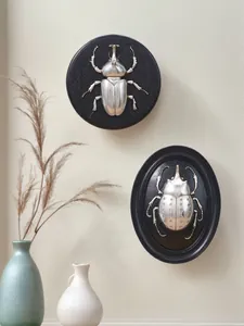 Dettaglio di rilievo di scarabeo d'argento vintage su decorazione murale in resina nera.