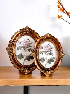 Detail of ornate gold vintage resin picture frames with botanical rose prints