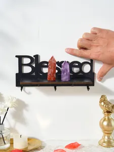 Vista dettagliata della mensola a muro in legno nero 'Blessed' con ganci e cristalli