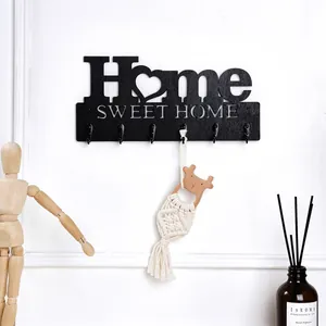 Schwarze Wandgarderobe mit 'Home Sweet Home'-Design und hängender Quastenverzierung