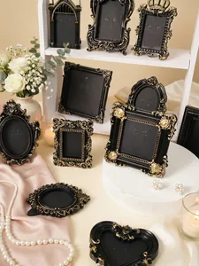 Detailed view of vintage black and gold embossed frames with elegant table decor.