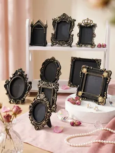 Detailed view of assorted French vintage black gold relief picture frames for desktop decor.