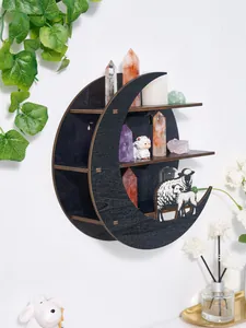 Elegant black crescent moon shaped wooden wall shelf displaying crystals and sheep decor