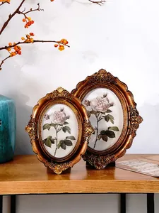 Close-up of vintage bronze resin photo frames with ornate floral carvings and roses