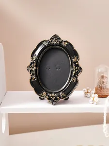 Vintage French style oval picture frame with ornate black and gold embossed details