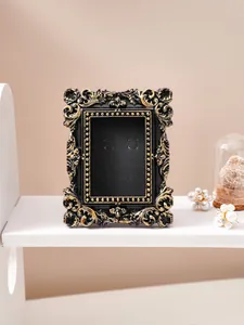 Detail view of a vintage French-style black and gold relief photo frame ornament