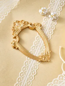 Gros plan détaillé d'un cadre photo vintage en résine dorée avec décoration en dentelle