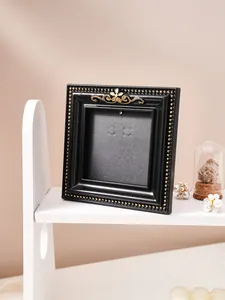 Exquisite retro black gold embossed picture frame earring display stand on white shelf