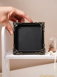 Detail view of vintage black gold relief picture frame on elegant white shelf